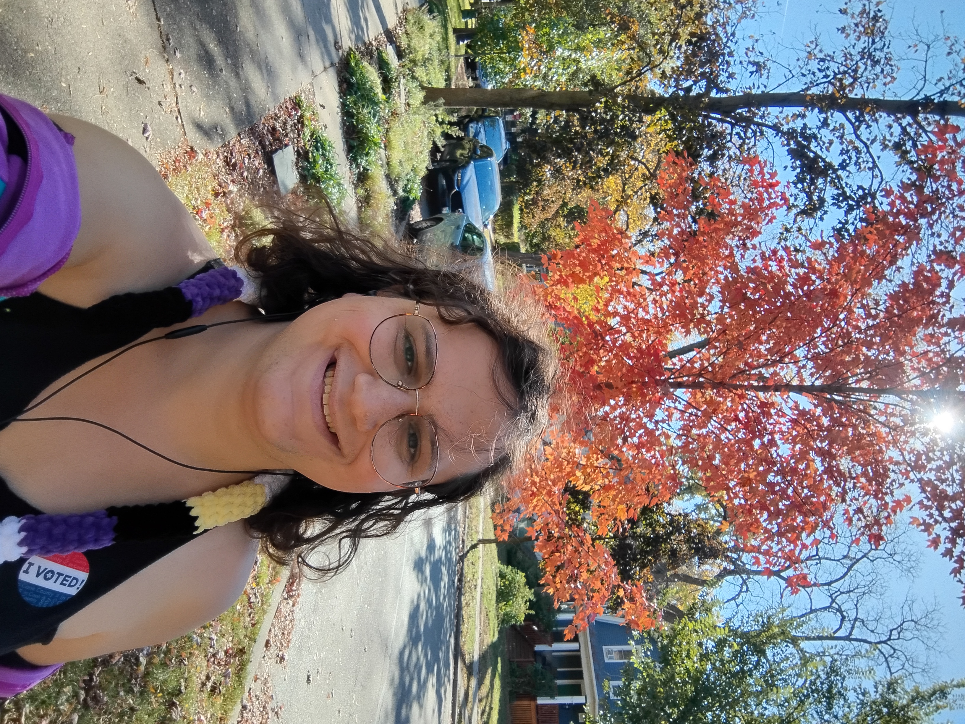 Me in front of a red tree with the sun through the leaves