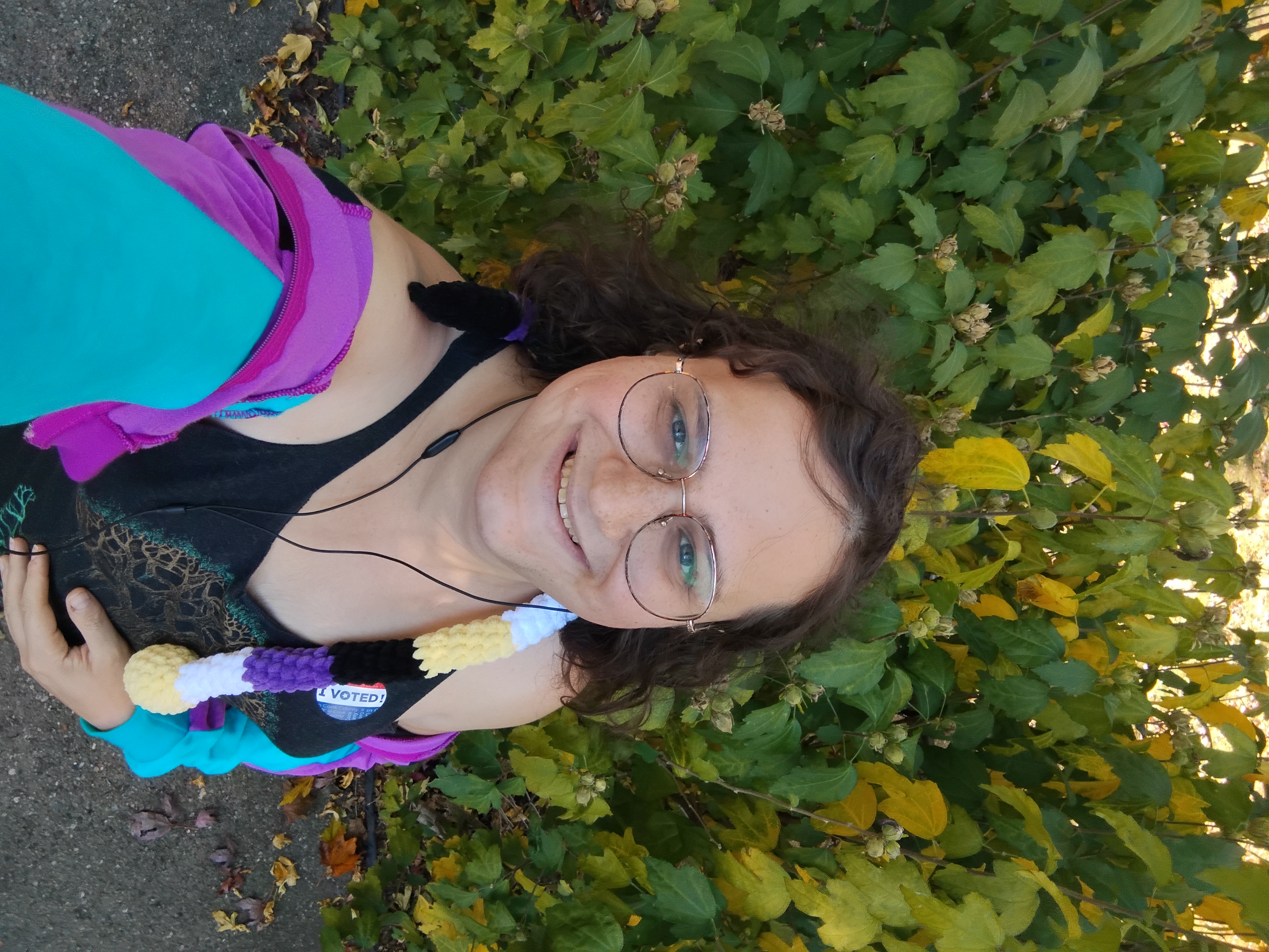 Me looking up at the camera with a leafy hedge behind me