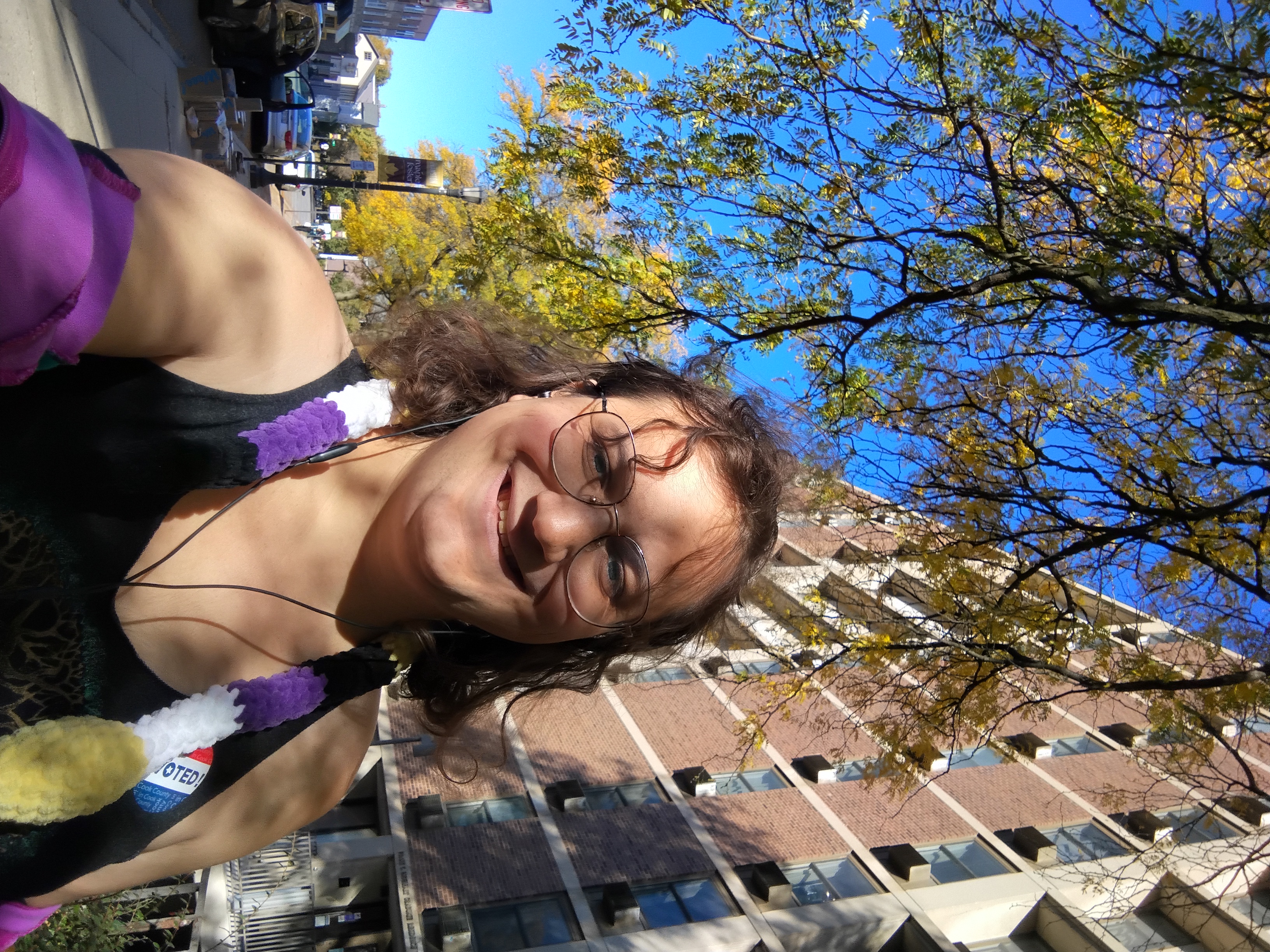 Me through dappled light with the sky and an apartment building behind me